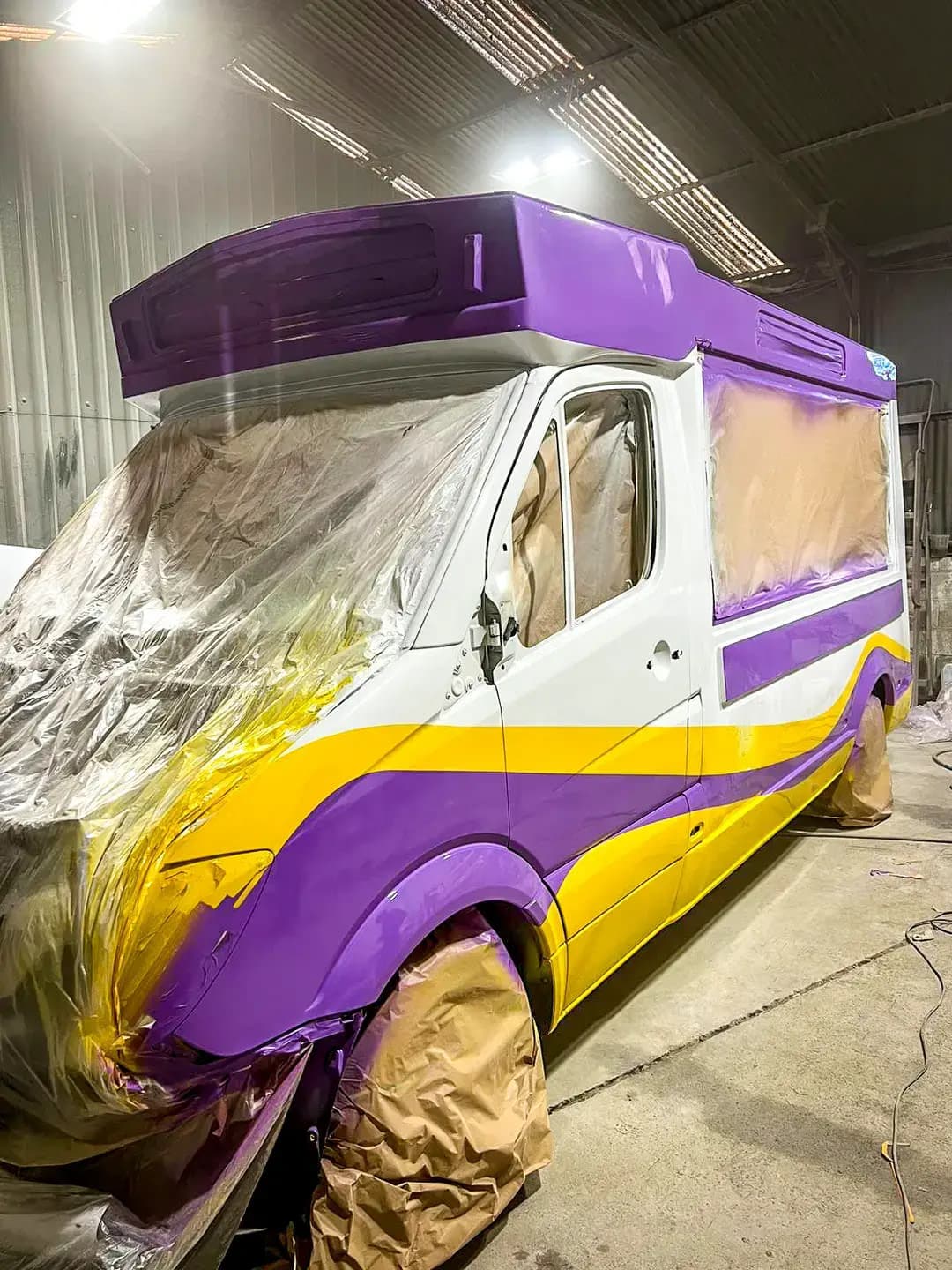 A van part-way through a respray into the purple and gold livery